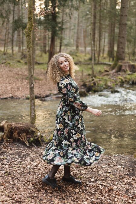Portrait Nadja Jeannine vor einem Bach im Wald.